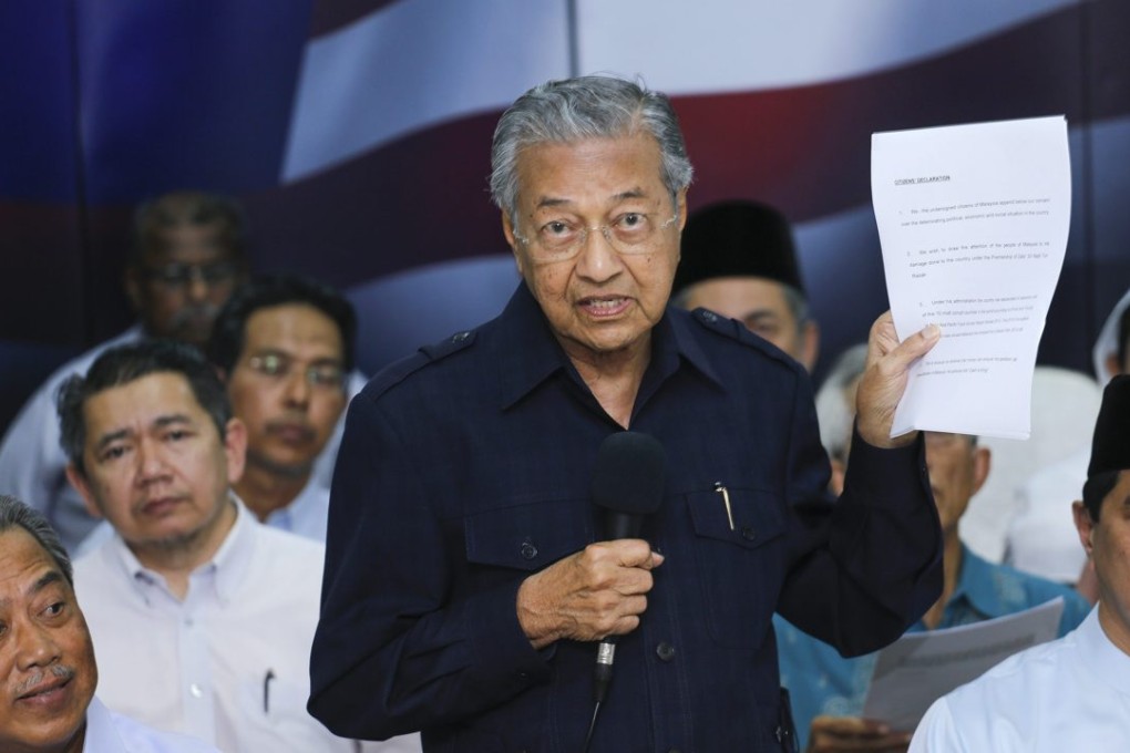 Former Malaysian Prime Minister Mahathir Mohamad holds up the anti-Prime Minister Najib Razak declaration. Photo: EPA