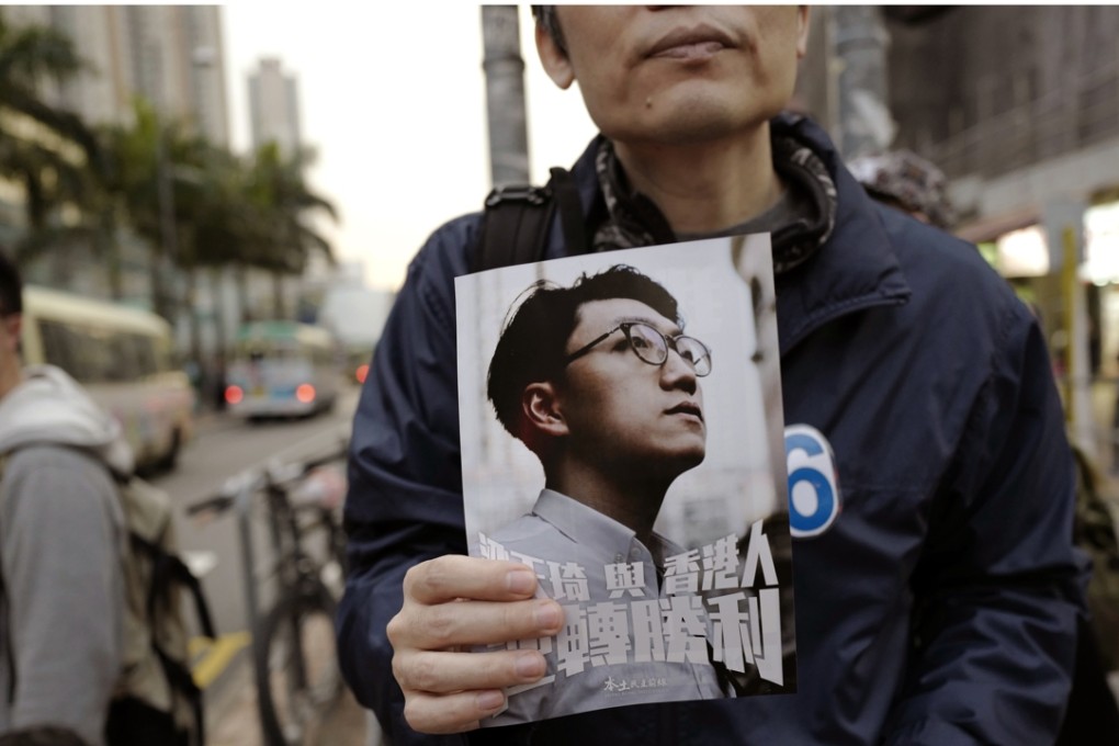 A supporter of localist activist Edward Leung holds up his picture at an election rally. Leung won over 15 per cent of the vote share. Photo: AP