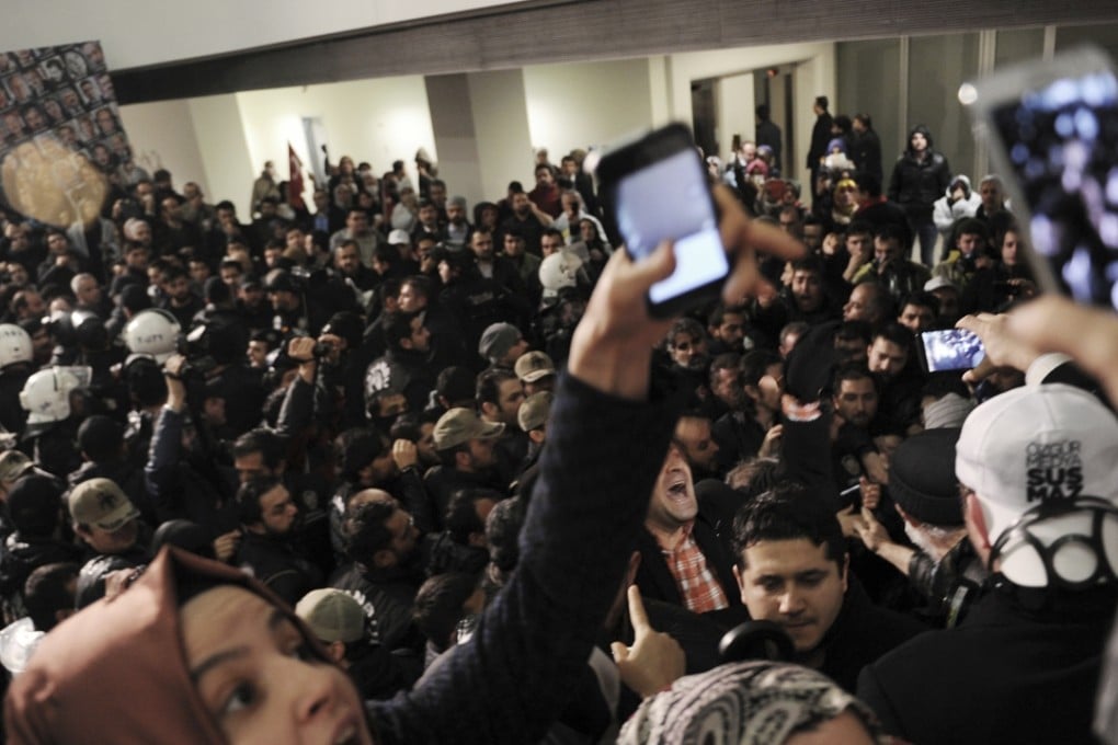Journalists react as riot police enter the headquarters of Turkey’s Zaman newspaper in Istanbul. photo: AP