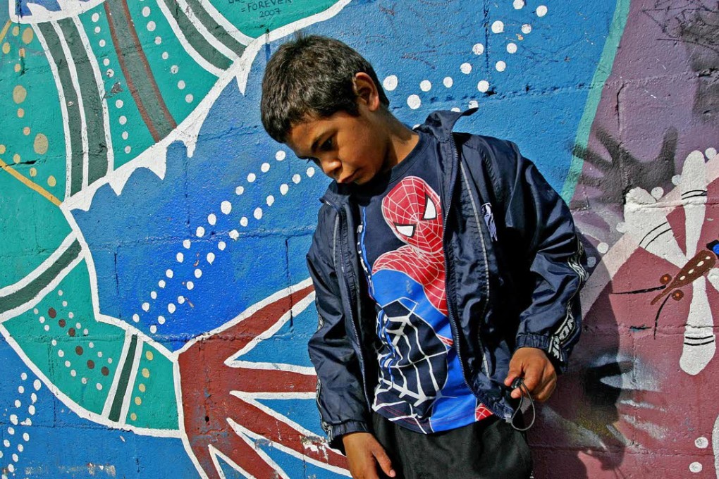 An Aboriginal child standing against a painted wall in 'The Block' in Sydney's inner-city suburb of Redfern. Photo: AFP