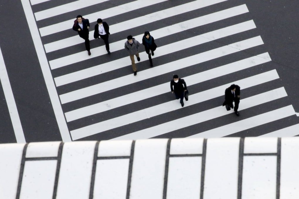 People cross a street in a business district in Tokyo, Japan, one of the countries to have resorted to negative interest rates. Photo: Reuters