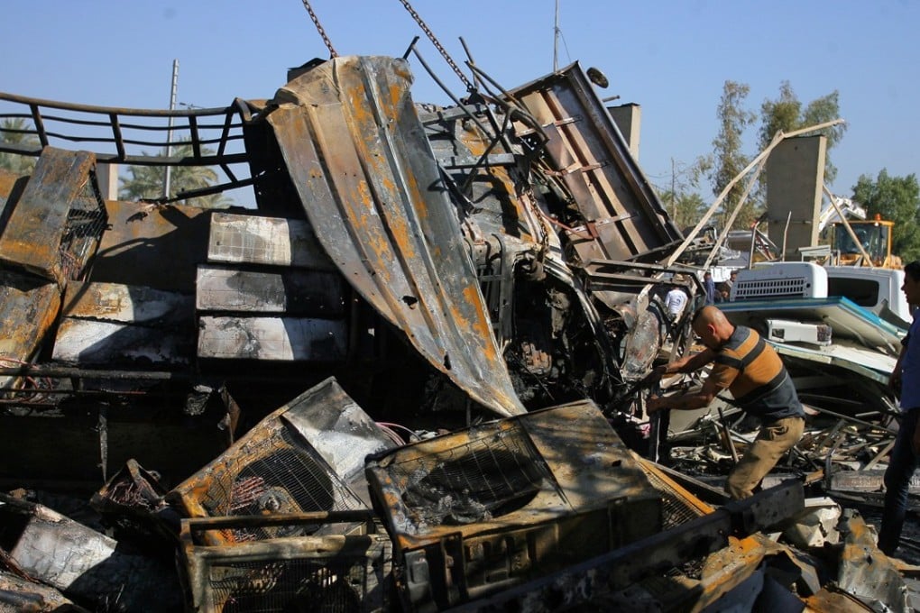 People gather at the site where a suicide truck bomb hit a crowded security checkpoint in Hillah, Iraq. Photo: Xinhua