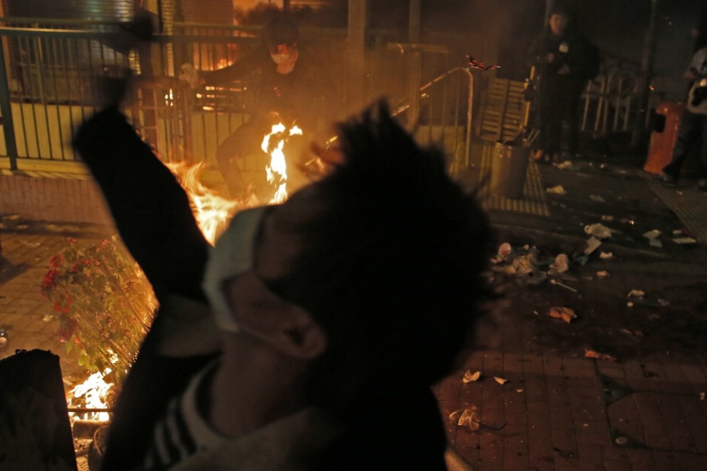 A protester throws a brick at police in Mong Kok last month. Photo: AP