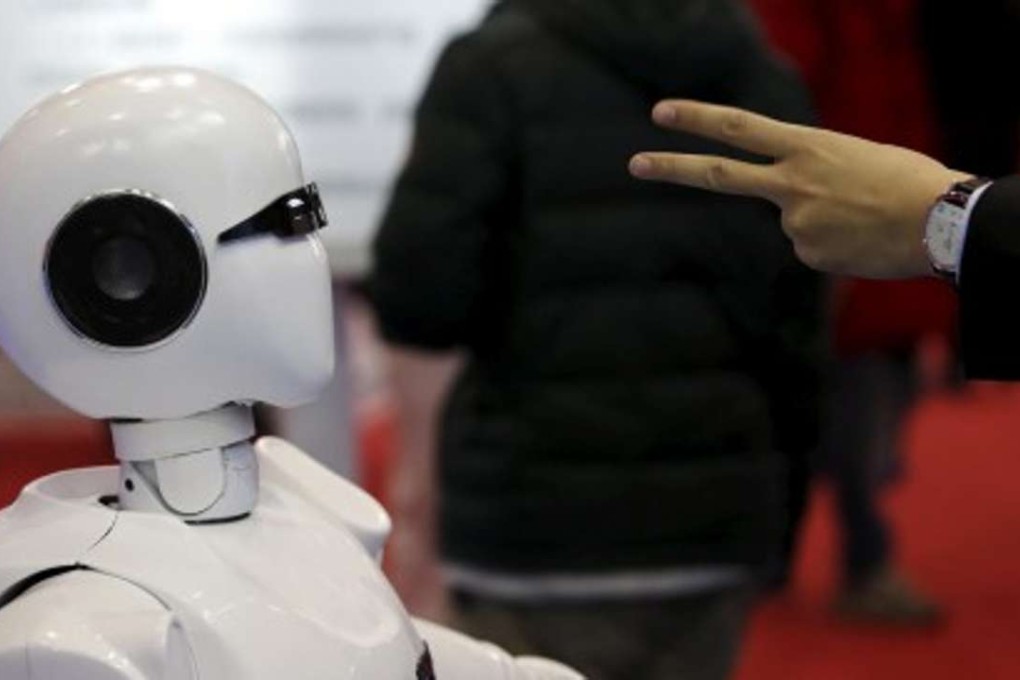 A visitor gestures to an android at the World Robot Conference in Beijing last November, where China showcased a version of its space robot as its robotics industry takes off. Photo: Reuters