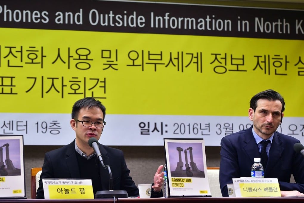 Amnesty researcher Arnold Fang (left) speaks at media conference on restrictions on phones in North Korea. Photo: AFP