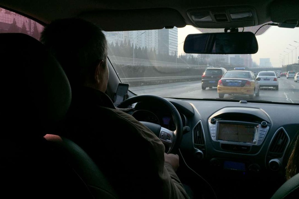 A cabbie in Beijing takes a request from a car-hailing app in this file photo. Some local governments in China have started muscling in on the private car -and taxi-hailing app business, and Guangzhou now has an app of its own and has teamed up with local taxi operators. Photo: Simon Song.