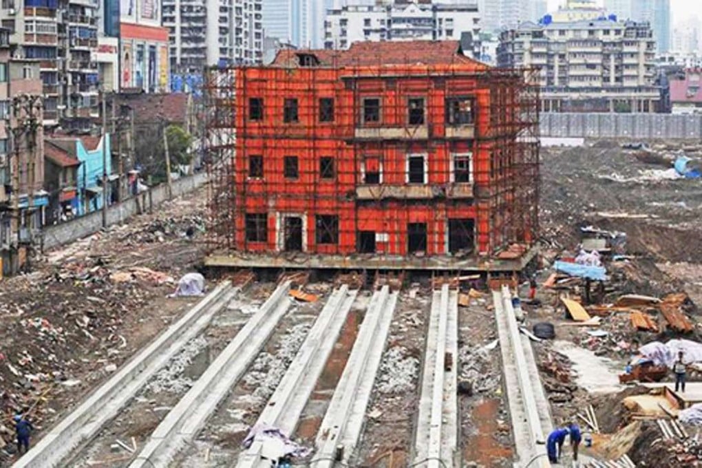The historic building in the city of Wuhan has been lifte 1.4 metres off the ground onto a new base so it can be moved 90 metres on six concrete rails to make way for redevelopment of the site. Photo: Qq.com