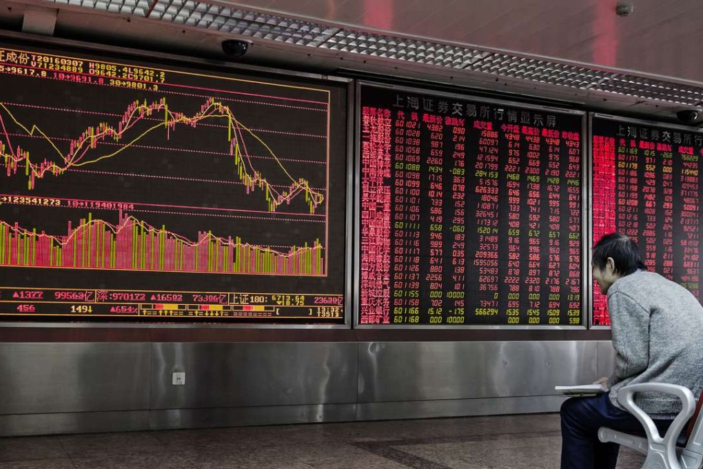 A man sits in front of an electronic board displaying share prices at a securities brokerage in Beijing. Photo: Bloomberg