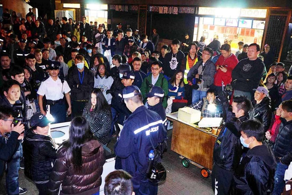 Police officers stopping hawkers from operating outside Leung King Plaza last month in Tuen Mun. Photo: SCMP Pictures