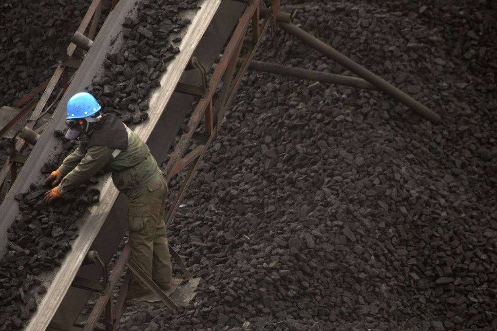 A worker checks coal carried along conveyor ramps at a mine near Ordos in north China’s Inner Mongolia. Coal has been increasingly blamed as a major contributor to the nation’s smog crisis as it accounts for more than 60 per cent of the mainland’s energy mix. Photo: AP