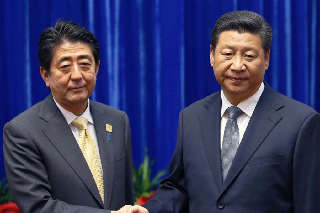 Tension shows on the faces of Shinzo Abe and Xi Jinping as they shake hands at their meeting in the Great Hall of the People. Photo: Reuters