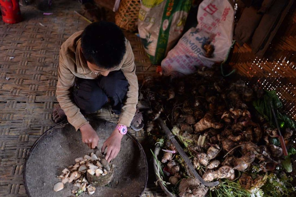 A teenager helps to cook for the family at home in Mukeji village, deep in the Gaoligong Mountains, in impoverished western Yunnan.A much-debated draft charity law went through a third reading at the National People’s Congress last week and a fourth draft will be submitted for approval on Wednesday. Photo: Hu Chao/Xinhua