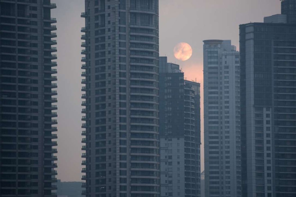 The sun rises over residential buildings in Pudong New Financial district, in Shanghai on March 14, 2016. Photo: AFP