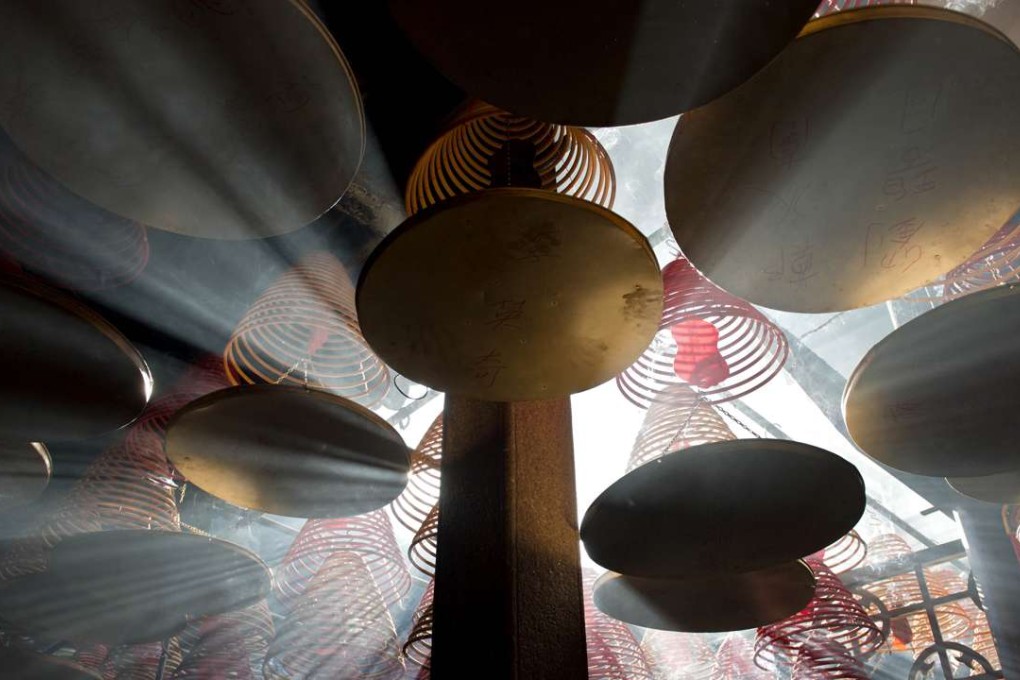Sunlight shines through hanging incense coils at the Tin Hau Temple in Yau Ma Tei. Photo: AFP