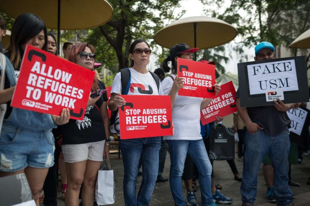 Asylum seekers and supporters hold placards to show their solidarity with Middle East refugees seeking shelters in European countries during a rally in Hong Kong. Photo: EPA