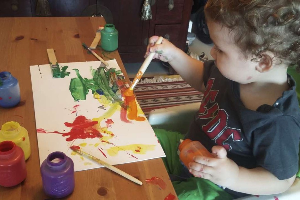 Leon, 18 months old, paints at home. We Play At Home maps out theme- and project-based activities for each child.