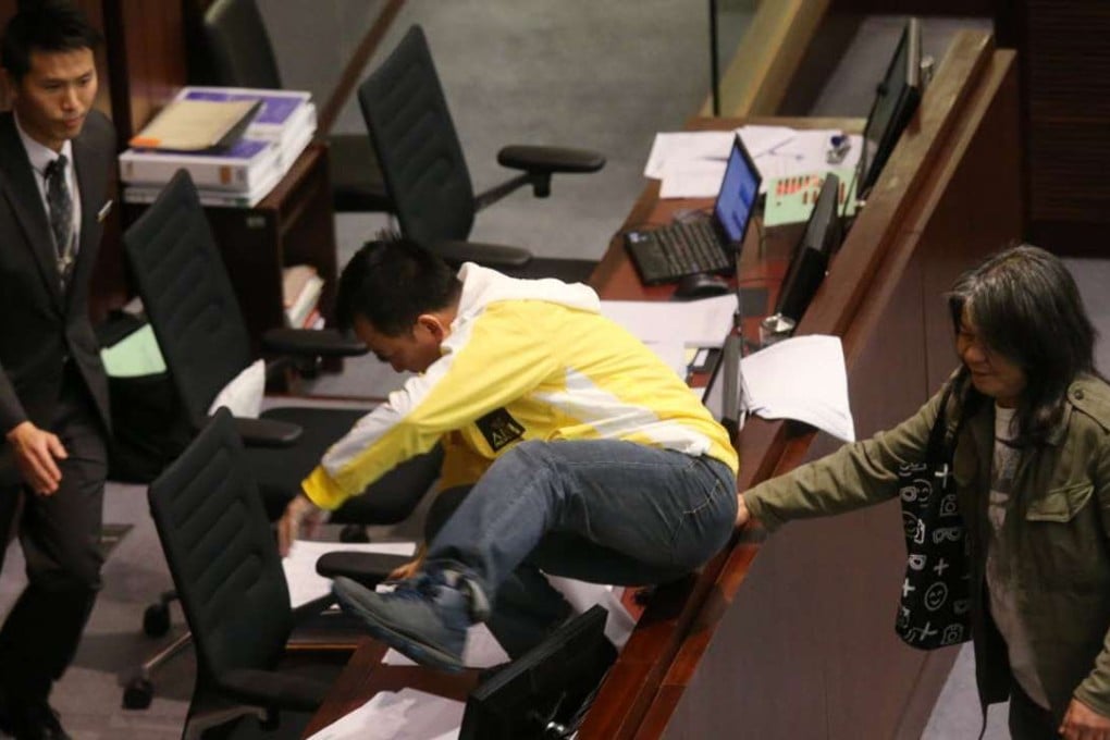 Raymong Chan (Middle) jump over a table at the Finance Committee meeting. Photo: Dickson Lee
