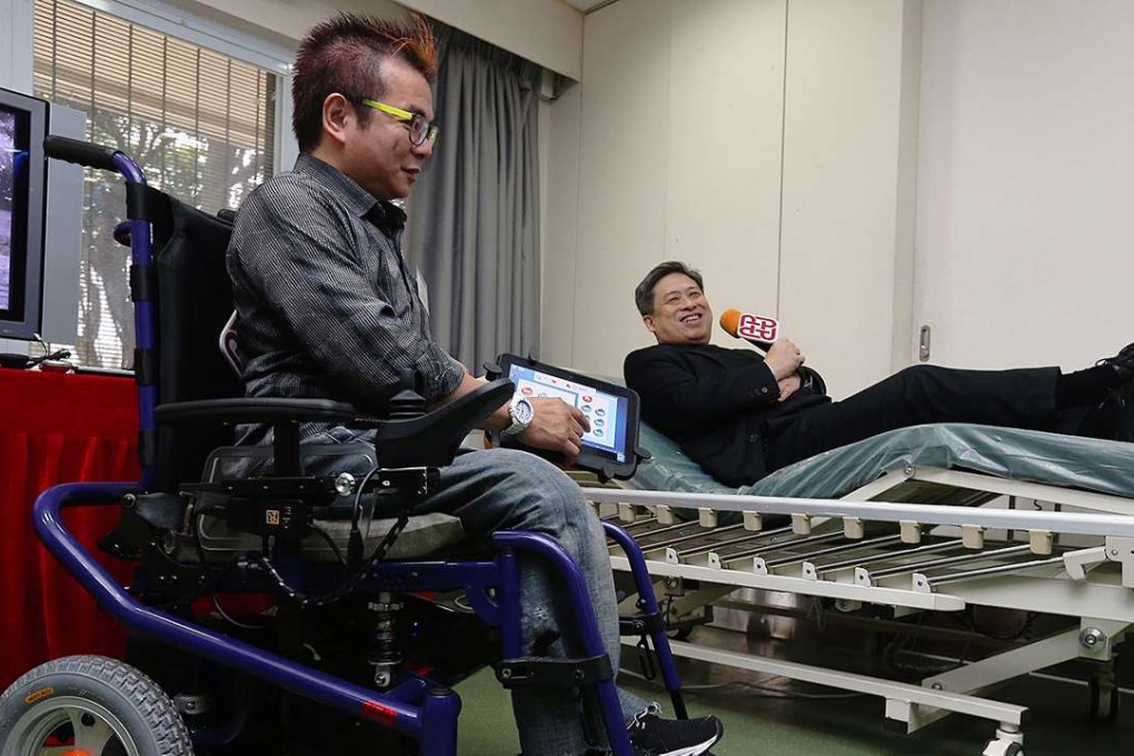 Philip Wong sits on an iWheelchair as Dr Eric Tam Wing-cheung of Polytechnic University looks on. Photo: Dickson Lee