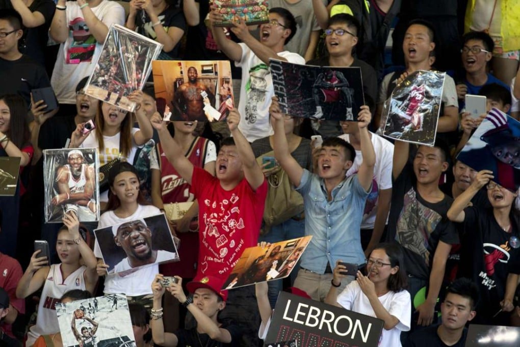 Fans of NBA basketball star LeBron James cheer his arrival at a Nike-sponsored event in Beijing, in 2014. Basketball is hugely popular in China, but are fans ready to pay to watch? Photo: AP