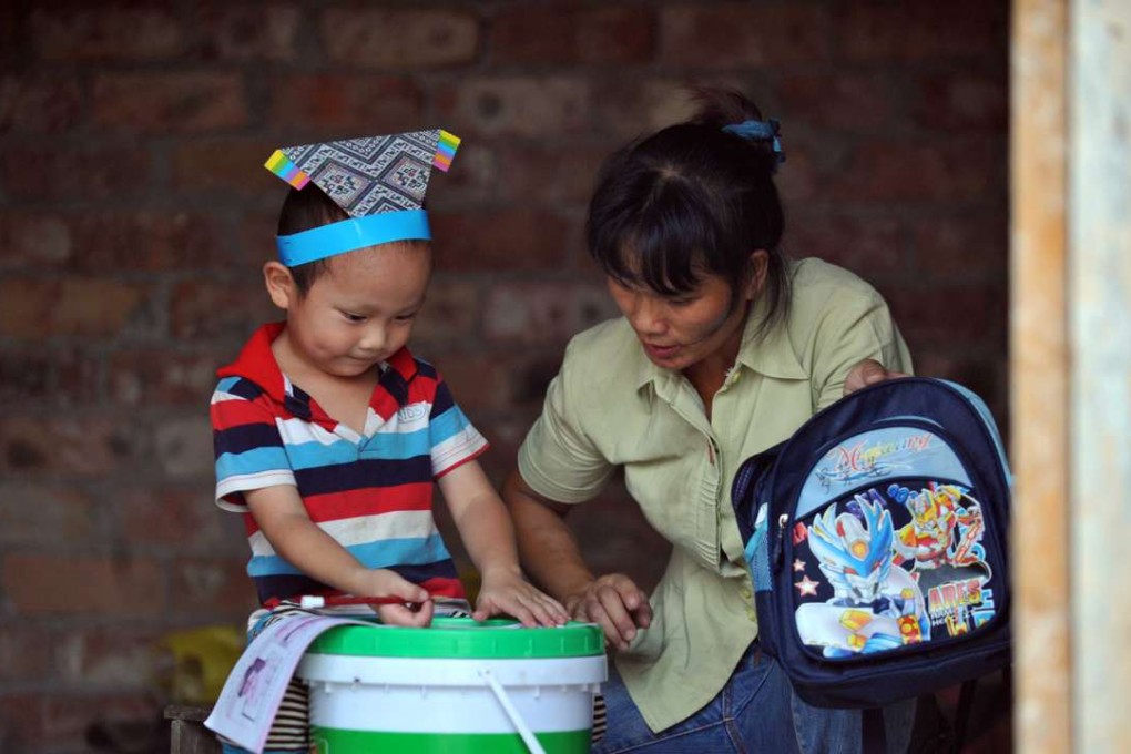 A learns Chinese characters on a paint bucket in Baise, southwest China's Guangxi Zhuang Autonomous Region. China’s national legislature passed the mainland’s first charity law on Wednesday. Photo: Xinhua