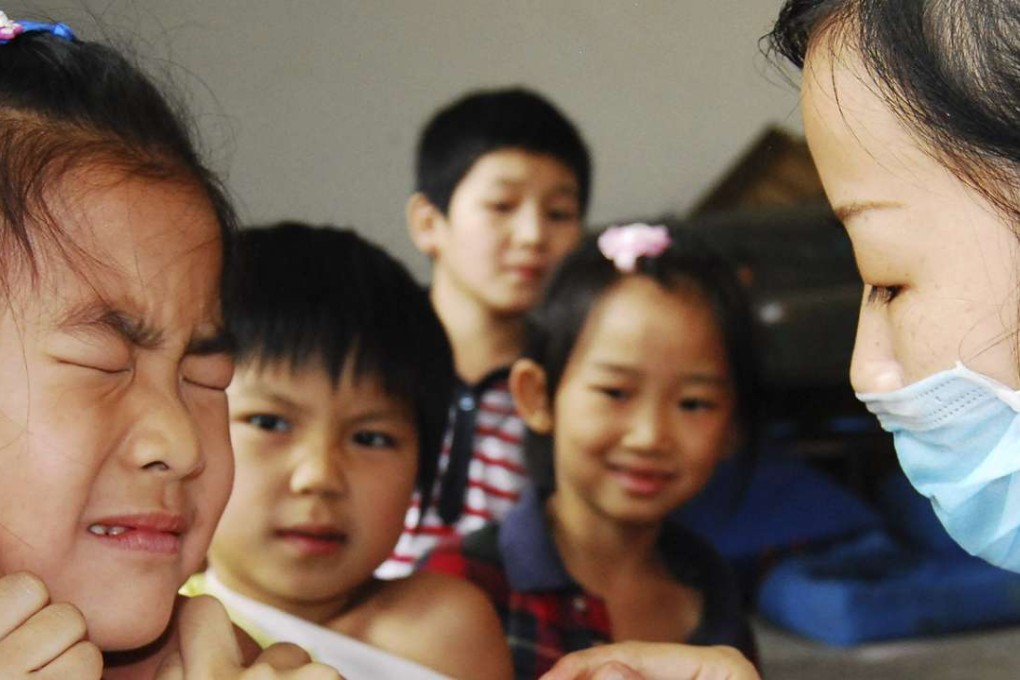 A Chinese pupil winces as she receives a vaccination in a school in Chenzhou, Hunan province. Photo: Reuters