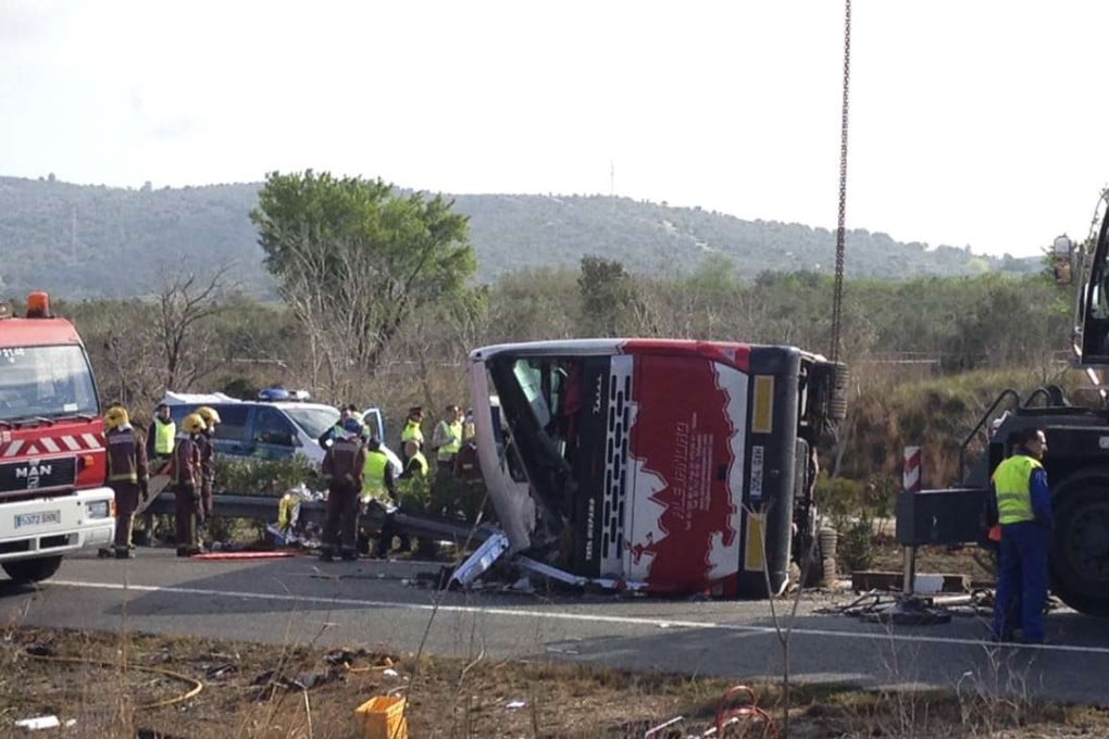 Emergency services personnel stand at the scene of a bus accident on the AP7 highway that links Spain with France halfway between Valencia and Barcelona. Photo: AP