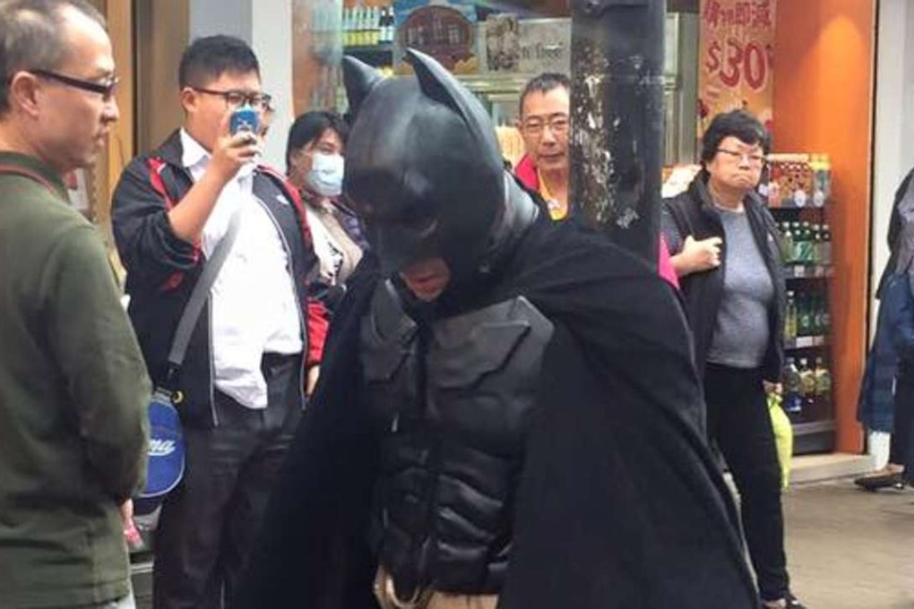 Onlookers snap photographs of Batman in Mong Kok. Photo: Facebook