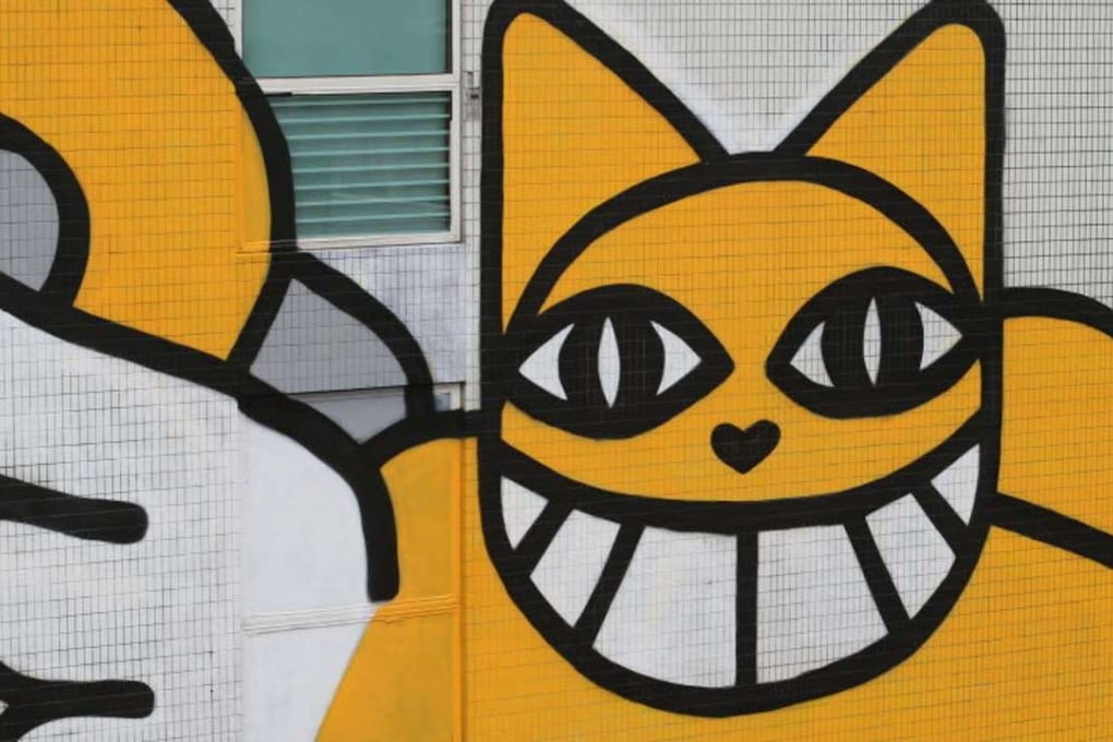 The yellow grinning cat on the side of Hotel Jen. Photo: Felix Wong