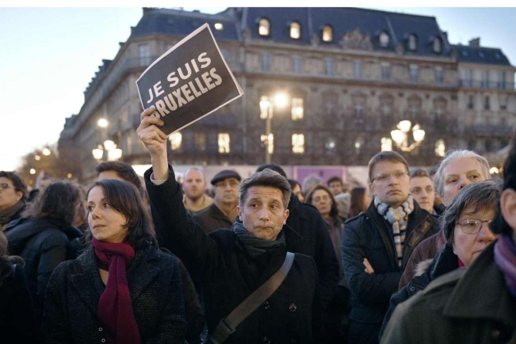 A man holds a placard that reads “I am Brussels” in front of the Hotel de Ville in Paris as people gather to mourn the victims of the attacks. Photo: AFP