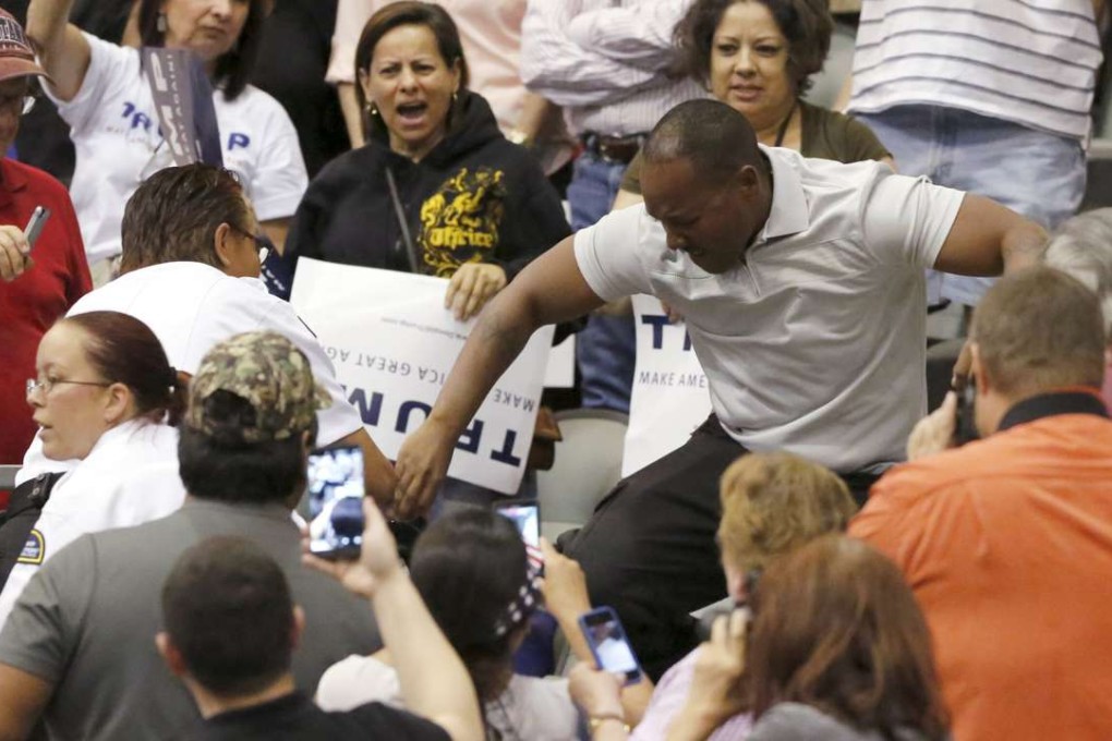 A member of the audience stamps on a protester during a campaign event for Donald Trump in Tucson, Arizona. Photo: Reuters
