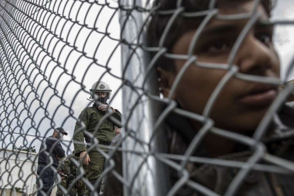 A Pakistani boy stands inside the Moria camp, in Greece, where hundreds of refugees and migrants are detained, during a demonstration against the new deal between the EU and Turkey. Photo: AFP
