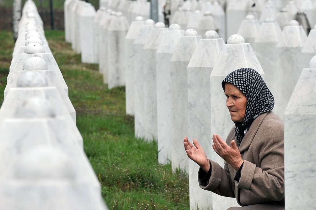 Bida Smajlovic, 64, prays by her husband’s grave at a memorial centre for victims of the 1995 Srebrenica massacre, in Potocari, on Thursday. Photo: AFP
