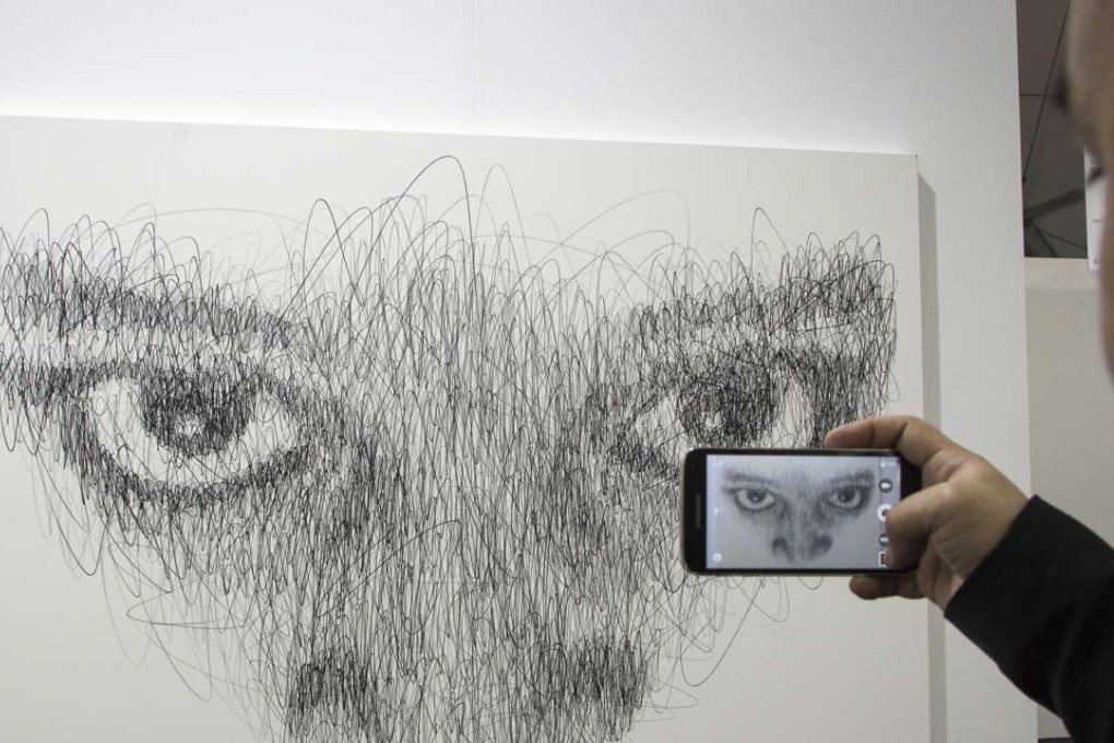 A visitor takes a photo of arwork Hidden, Black stone on canvas by French artist Hom Nguyen at Art Central on the harbourfront event space in Central, Hong Kong. Photos: Tessa Chan