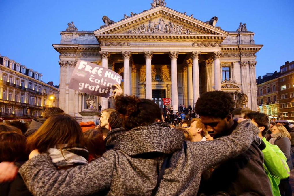 People gather at the Place de la Bourse in Brussels to leave messages and tributes following the terrorist attacks on March 22. Photo: PA Wire/Zuma Press/Tribune News Service