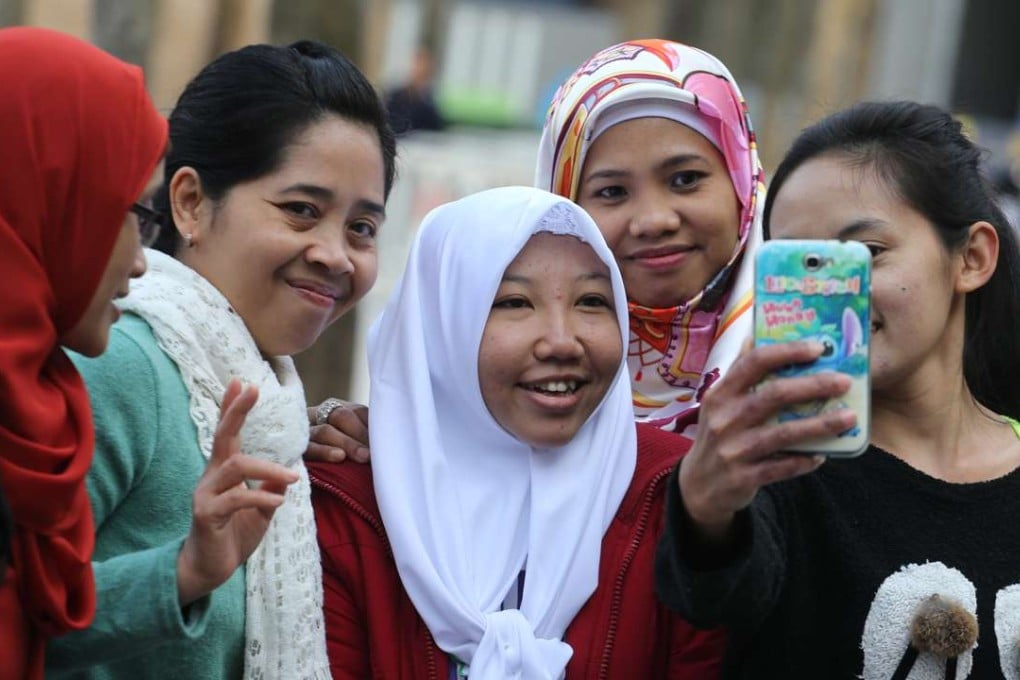 Erwiana Sulistyaningsih (white headscarf, centre), on a return visit to the city. Photo: Felix Wong