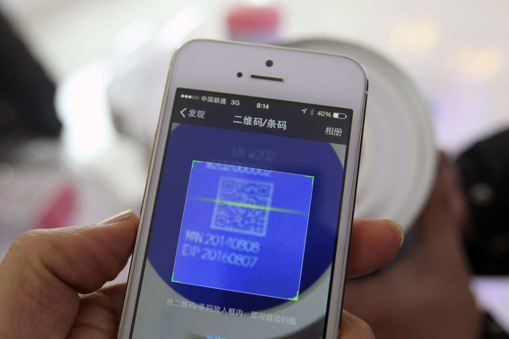 A mobile phone is scanning the QR Code on the bottom of the can of a Pinguan baby formula powder produced by Heilongjiang Red Star Group in Mudanjiang City, Heilongjiang province in this photo dated December 2, 2014. Photo by Simon Song