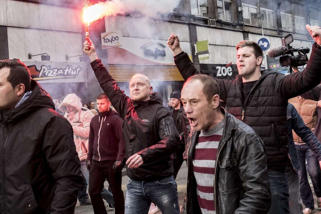 Self-proclaimed "hooligans" protest at a memorial site for the victims of the Brussels bombings. Photo: Polet/Reporters/Zuma Press/Tribune News Service