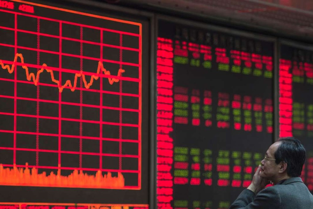An investor watches stock prices on screens at a securities company in Beijing. Photo: AFP