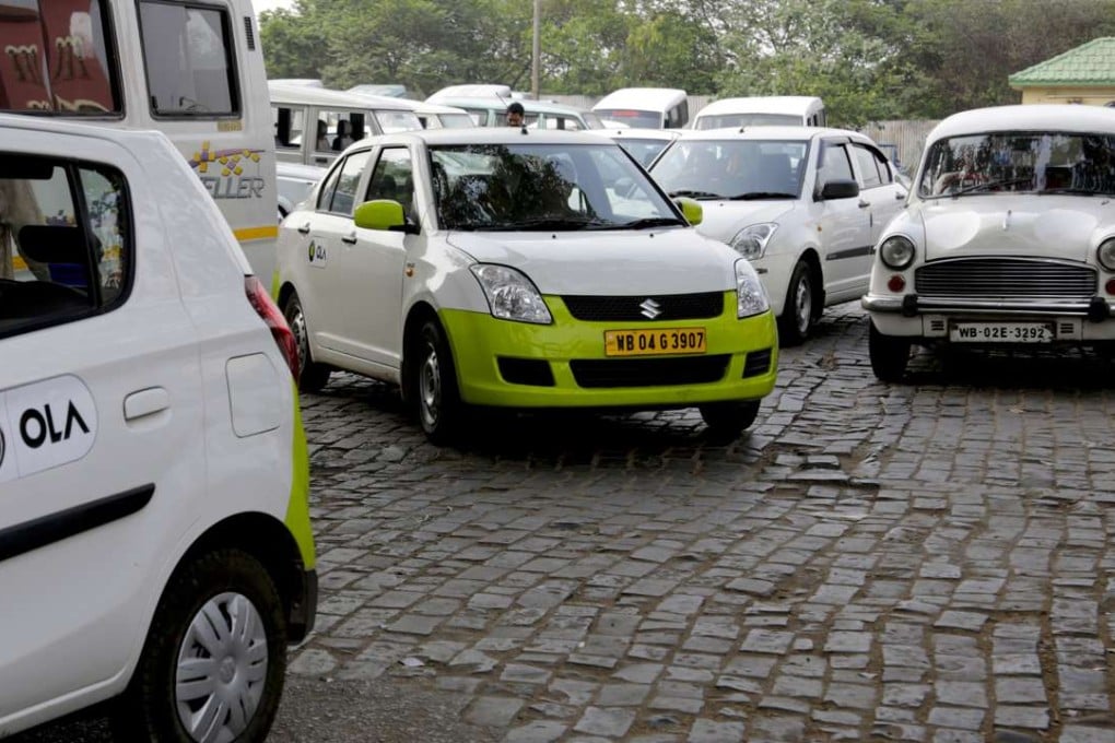 Ola cabs waiting for customers are parked next to other cars in Kolkata, India. Photo: AP