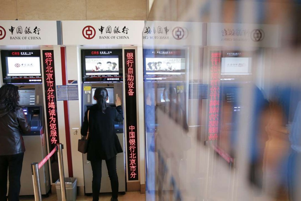 People use ATM's inside the Bank of China head office building in Beijing on March 30, 2016. Photo: Reuters