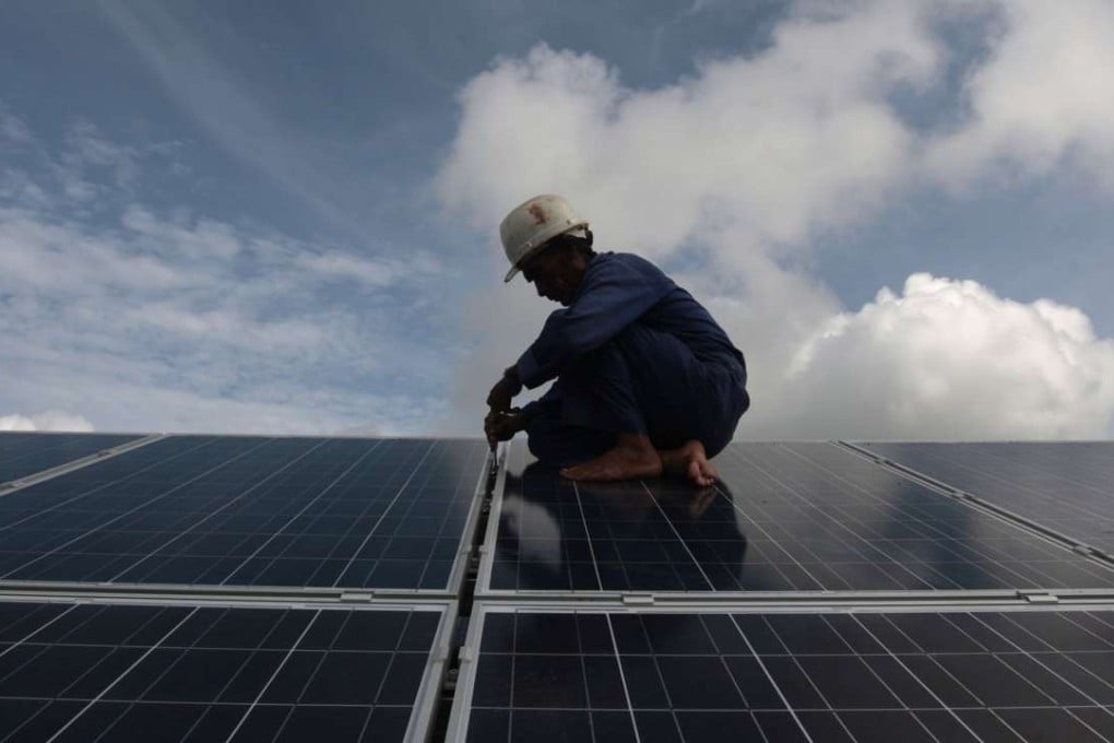 A worker adjusts solar panels. India hopes to receive one of the Asian Infrastructure Investment Bank’s first loans for its solar power projects. Photo: Reuters