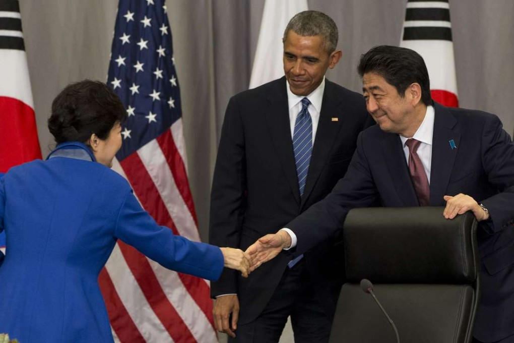 South Korean President Park Geun-hye, left, shakes hands with Japanese Prime Minister Shinzo Abe as President Barack Obama watches after their meeting at the Nuclear Security Summit in Washington, on Thursday, March 31, 2016. Photo: AP