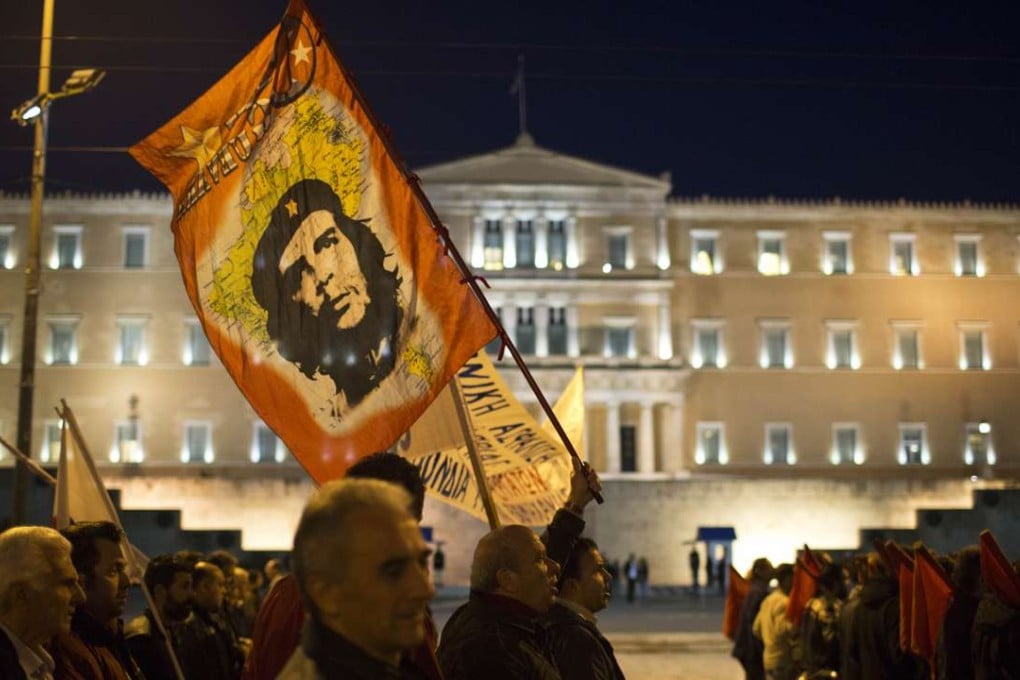 A protester holds a flag with the image of revolutionary hero Ernesto "Che" Guevara, as members of the Communist-affiliated PAME demonstrate outside the Greek parliament against new bailout measures in March. Photo: AP