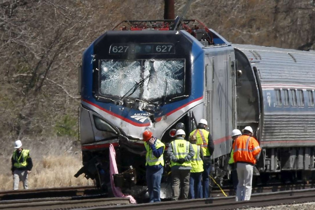 Emergency personnel examine the scene after an Amtrak passenger train struck a backhoe, killing two people, in Chester, Pennsylvania, on Sunday. Photo: Reuters