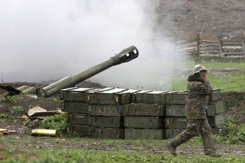 An Armenian covers his ears while a howitzer fires from an artillery position of the self-defense army of Nagorno-Karabakh near Martakert, Azerbaijan, on Sunday. Photo: AP