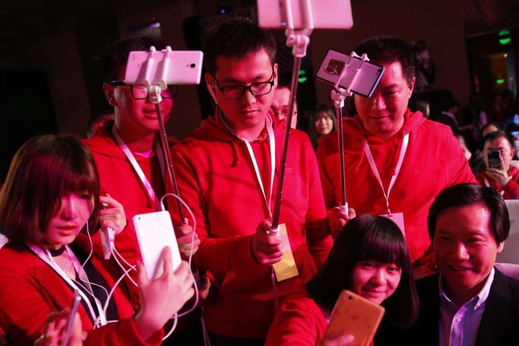 Fans of Xiaomi, pose and take photos with Lei Jun (R) , CEO of Chinese mobile internet company Xiaomi Technology Co. Ltd., before the Xiaomi product launch ceremony for the new Xiaomi 'Mi TV 3S' in Beijing, China. Photo: EPA