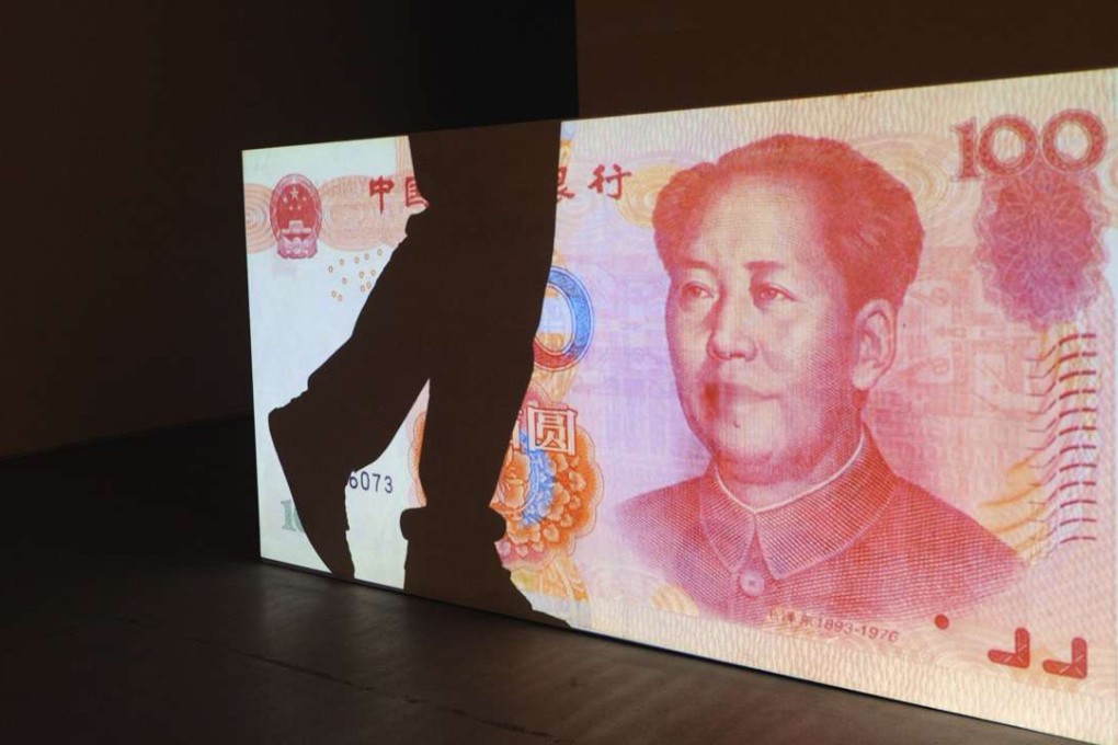 The shadow of a visitor falls on a huge 100-yuan note at an art exhibition in Beijing. Photo: AFP