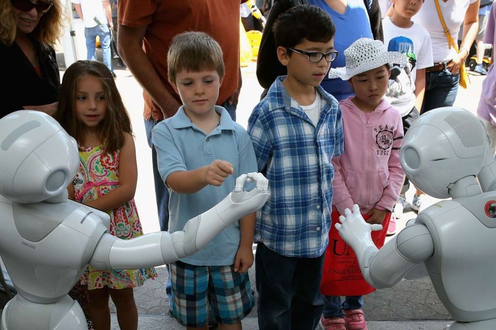 POMONA, CA - JUNE 06: Children interact with Aldebaran's Pepper robot during the Defense Advanced Research Projects Agency (DARPA) Robotics Challenge Expo at the Fairplex June 6, 2015 in Pomona, California. Organized by DARPA, the Pentagon's science research group, 24 teams from aorund the world are competing for $3.5 million in prize money that will be awarded to the robots that best respond to natural and man-made disasters. Chip Somodevilla/Getty Images/AFP == FOR NEWSPAPERS, INTERNET, TELCOS & TELEVISION USE ONLY ==