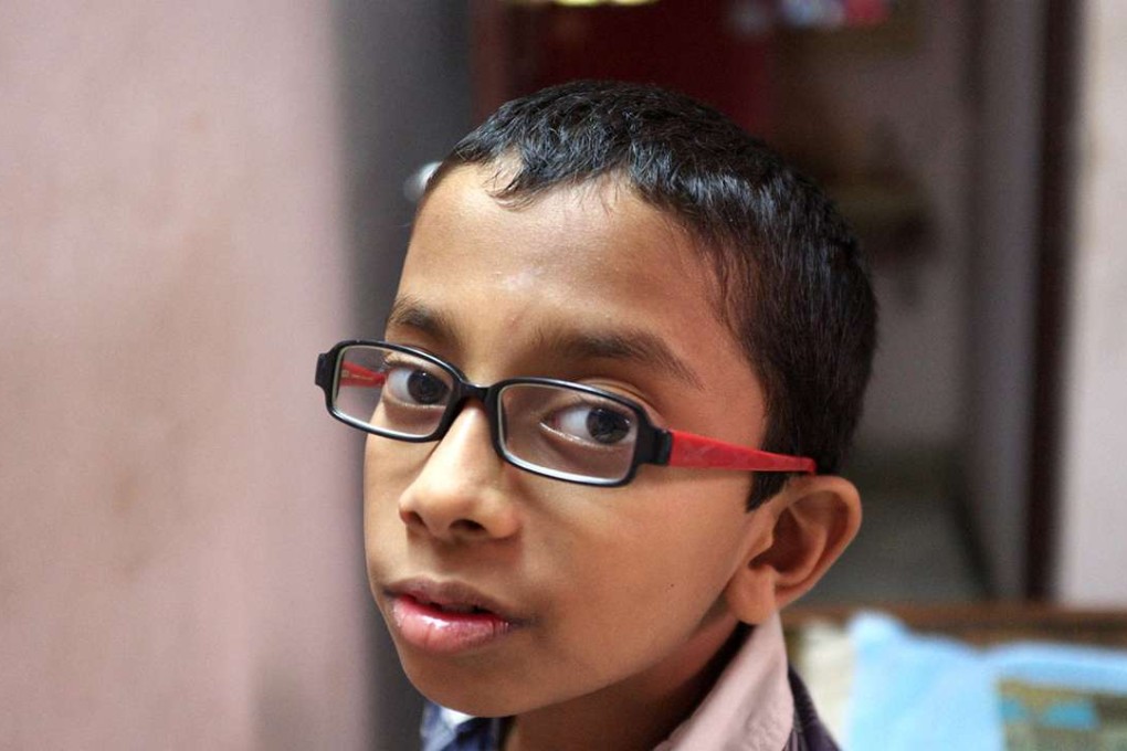 A child in Chennai, India, wears adjustable focus glasses created by Adlens. which has both a commercial arm and a humanitarian arm supplying inexpensive glasses in the developing world.