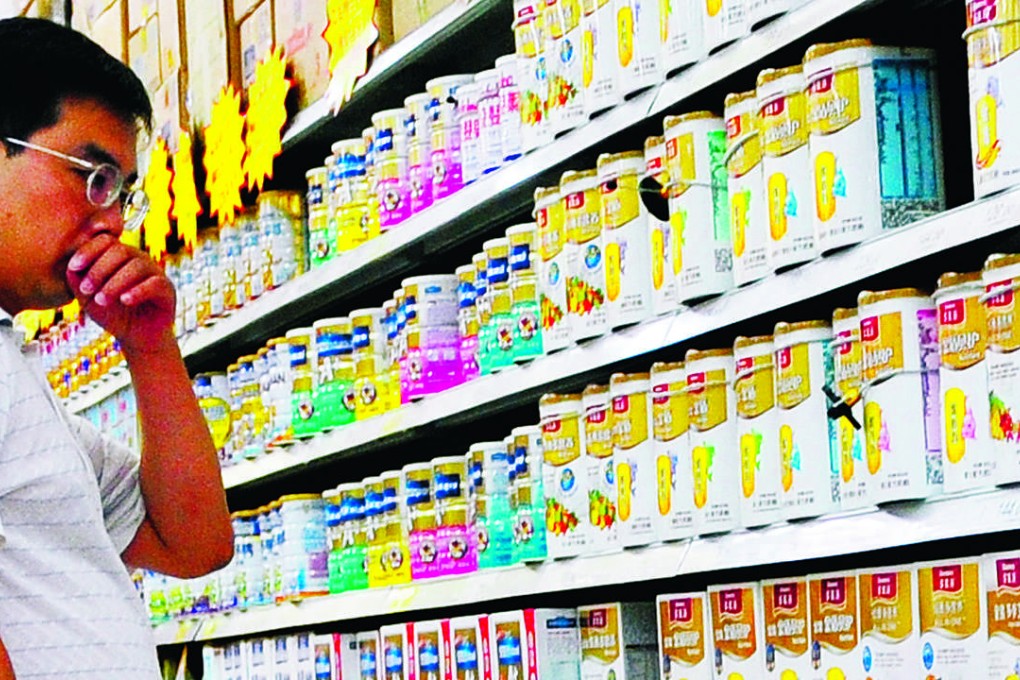 A Chinese man selects milk powder at a supermarket in Beijing. Photo: AFP